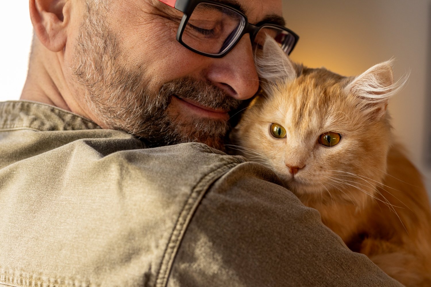 Man som kramar en röd katt